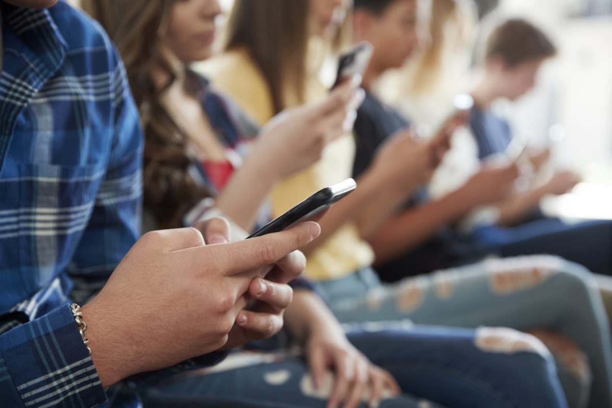 teenagers holding mobile phones