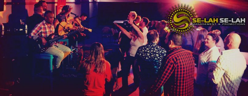 Photograph shows a group of musicians jamming