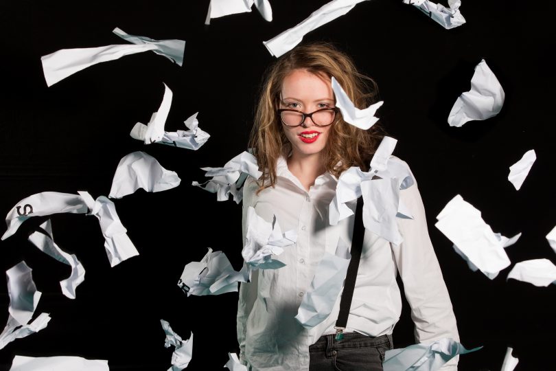 Photograph of woman surrounded by falling paper shreds