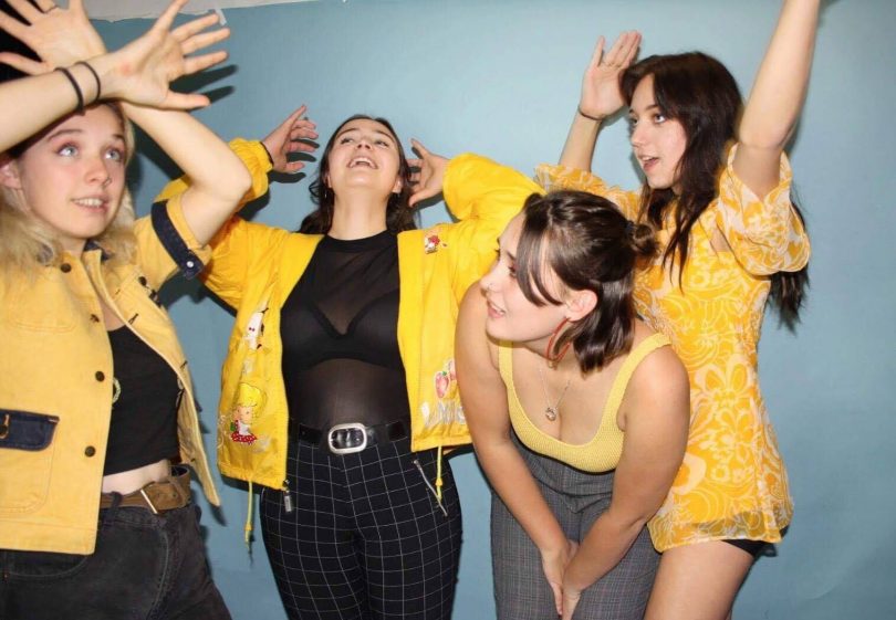 Photograph of four members of Teen Jesus and the Jean Teasers wearing yellow