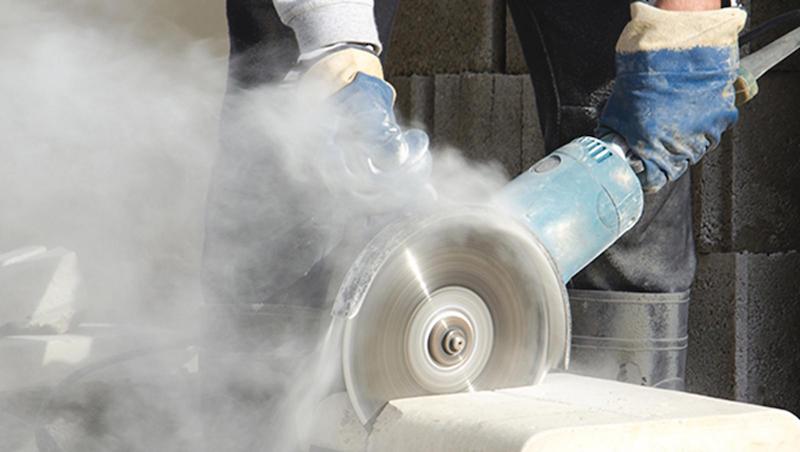 Worker cutting stone with grinder