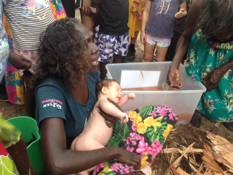 Yolngu smoking ceremony using pounded stringy bark at Yirrkala beach