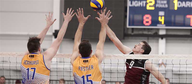 Three players reaching for a volleyball ball