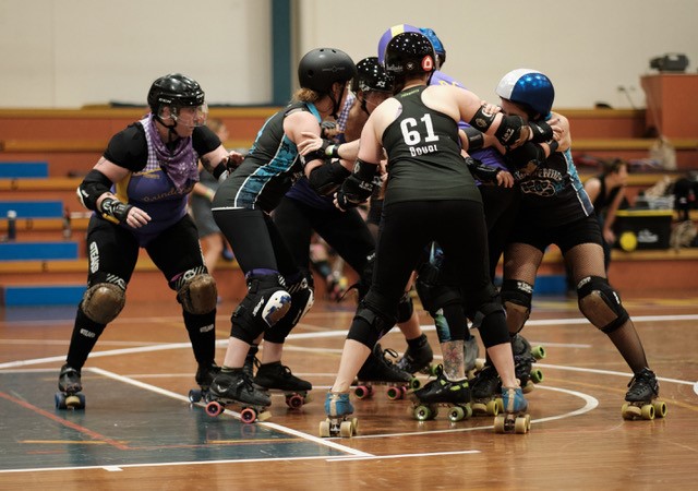 Brindabelters and Black and Blue Belles players in a pack playing for 3rd place