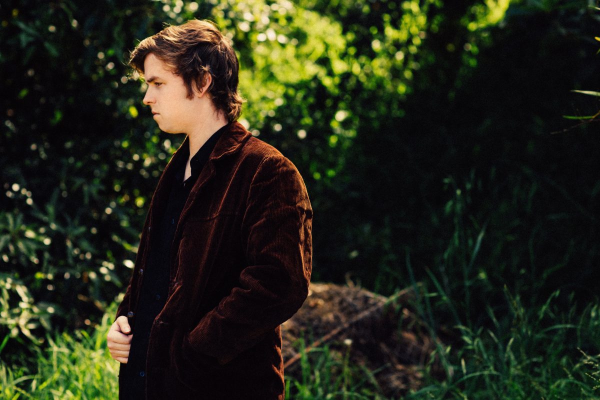 Photograph shows Tate Sheridan standing in a garden