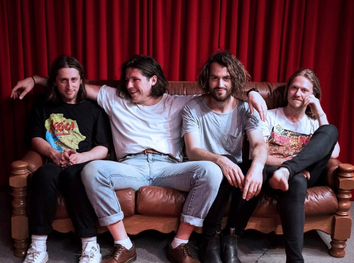 four men sitting on a couch