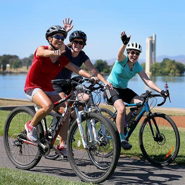 Three cyclists on bikes at Lake Burley Griffin in Canberra.