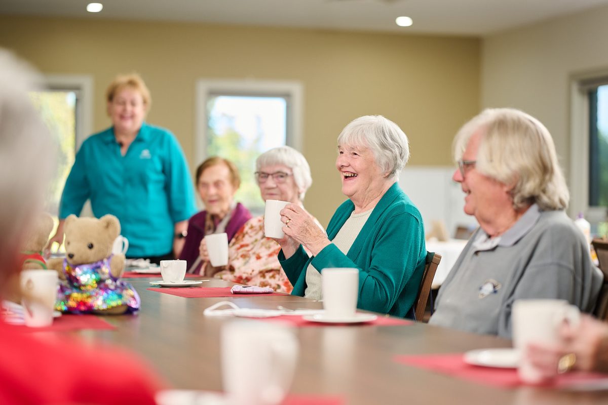 people smiling and laughing sitting around a table