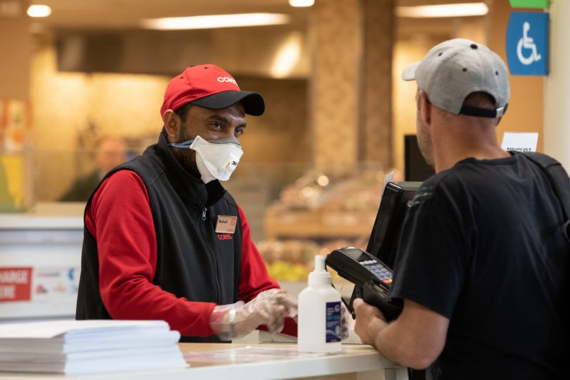 Coles supermarket employee with mask and gloves