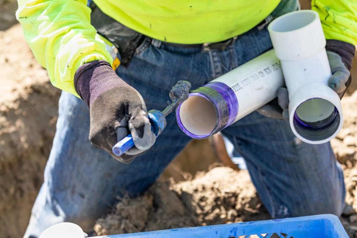 Plumber putting primer and glue on a pipe