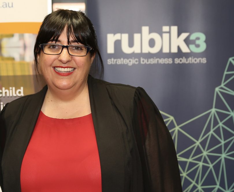 Nadia Pessarossi smiling in front of Rubik3 sign. 