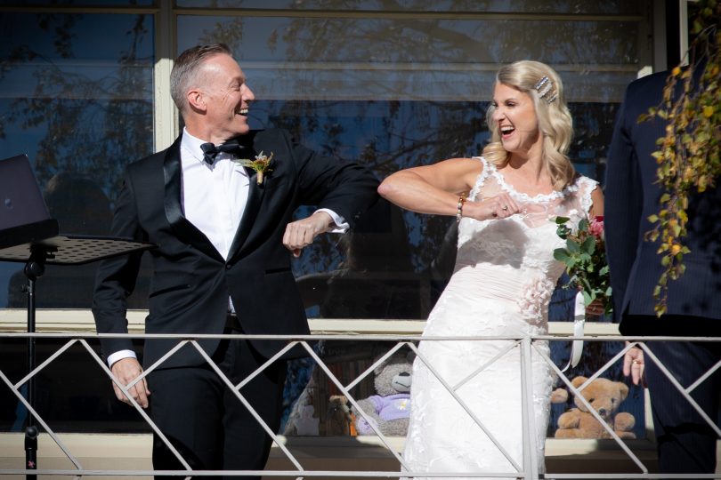 Canberra couple bump elbows during their COVID-19 wedding ceremony.