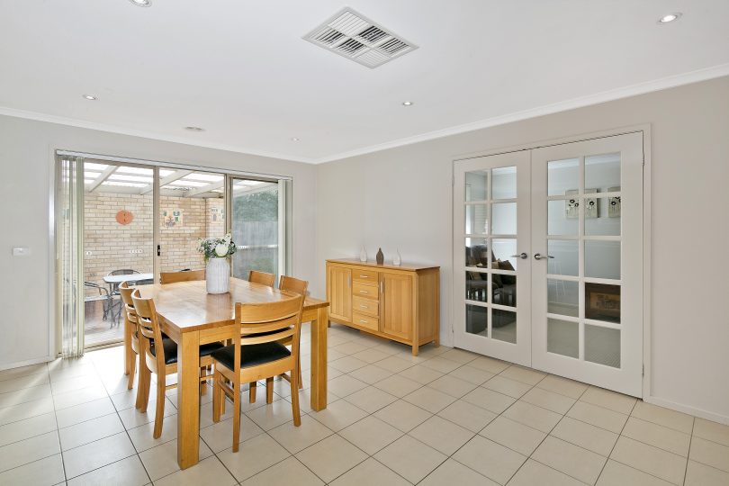 Dining room with the versatile rumpus room through glass doors.