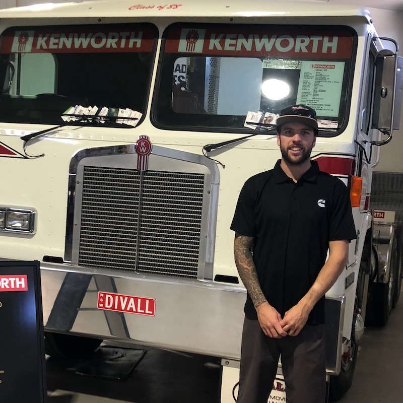 Riley Topping standing in front of Kenworth truck.