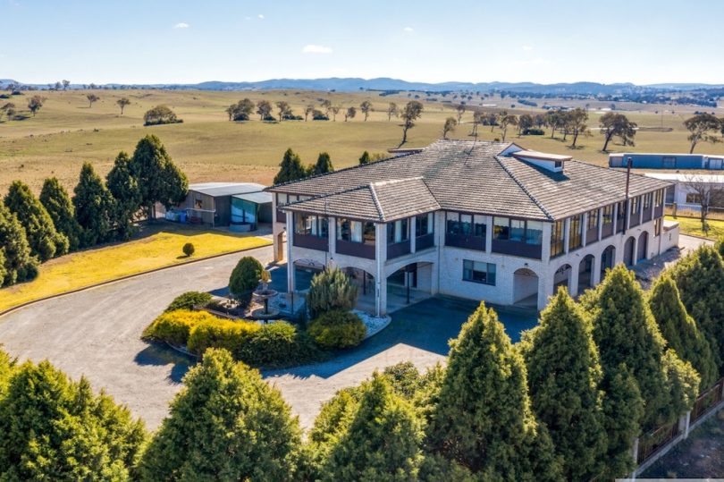 Aerial view of six-bedroom rural home among trees.