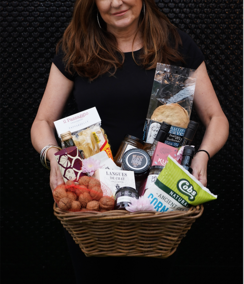 Woman holding basket of products from Pialligo Estate Grocer.