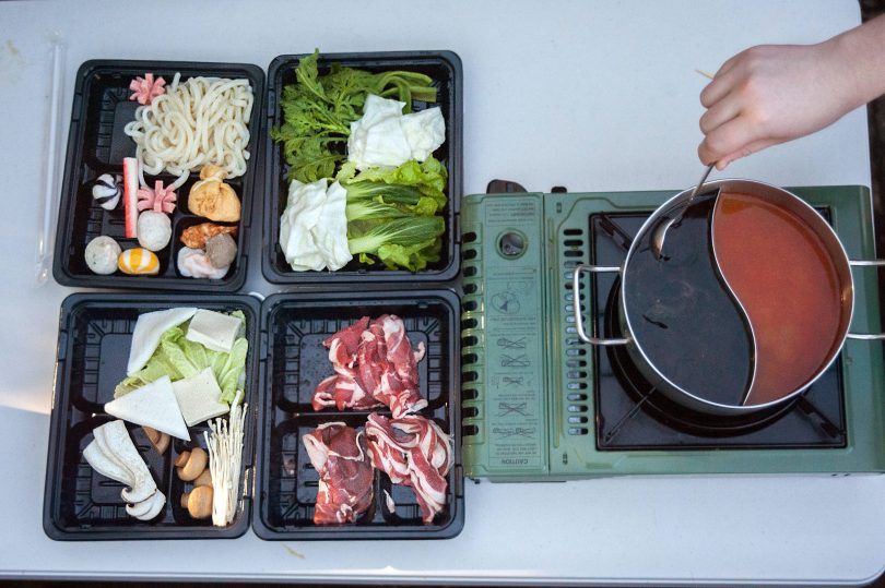 Fresh ingredients, stove-top and saucepan full of soup from 106 Hotpot.