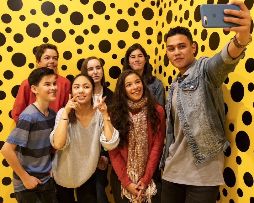 Group of people posing with installation of Spirits of the Pumpkins Descended into the Heavens at NGA.