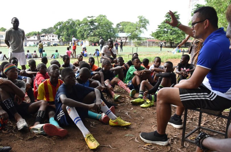 Kitsana "Jimmy" Muongsene addressing African children sitting on ground after training session.