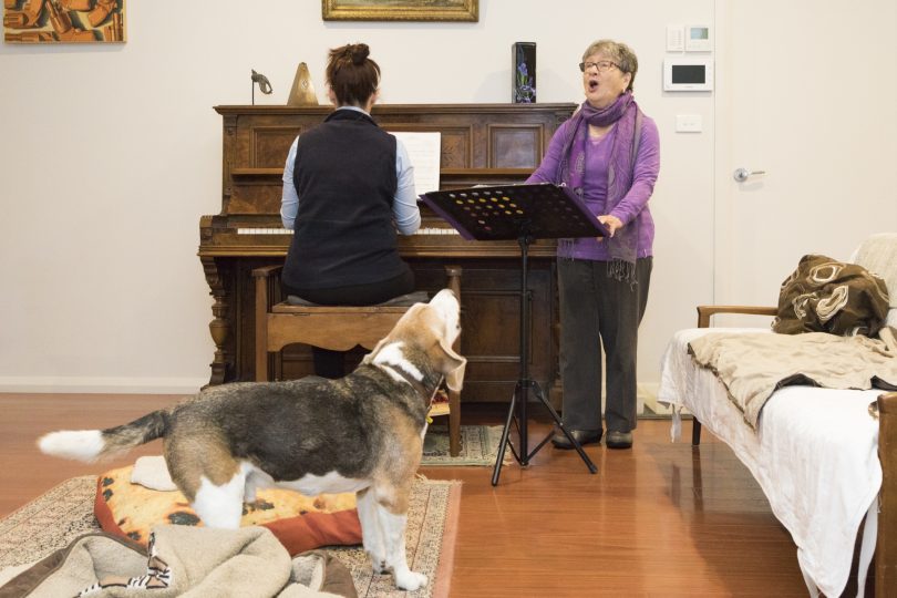 Yvonne singing, Catherine playing piano in front of Bill the beagle dog.