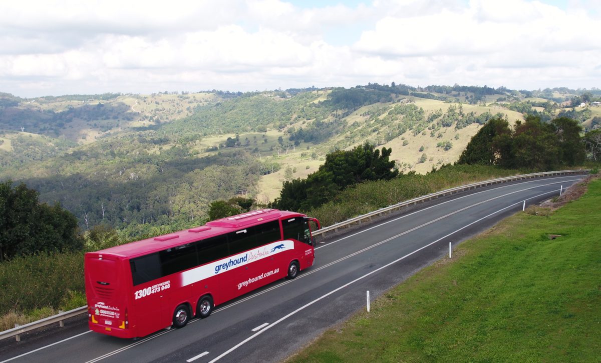 A Greyhound Australia bus on a country road.