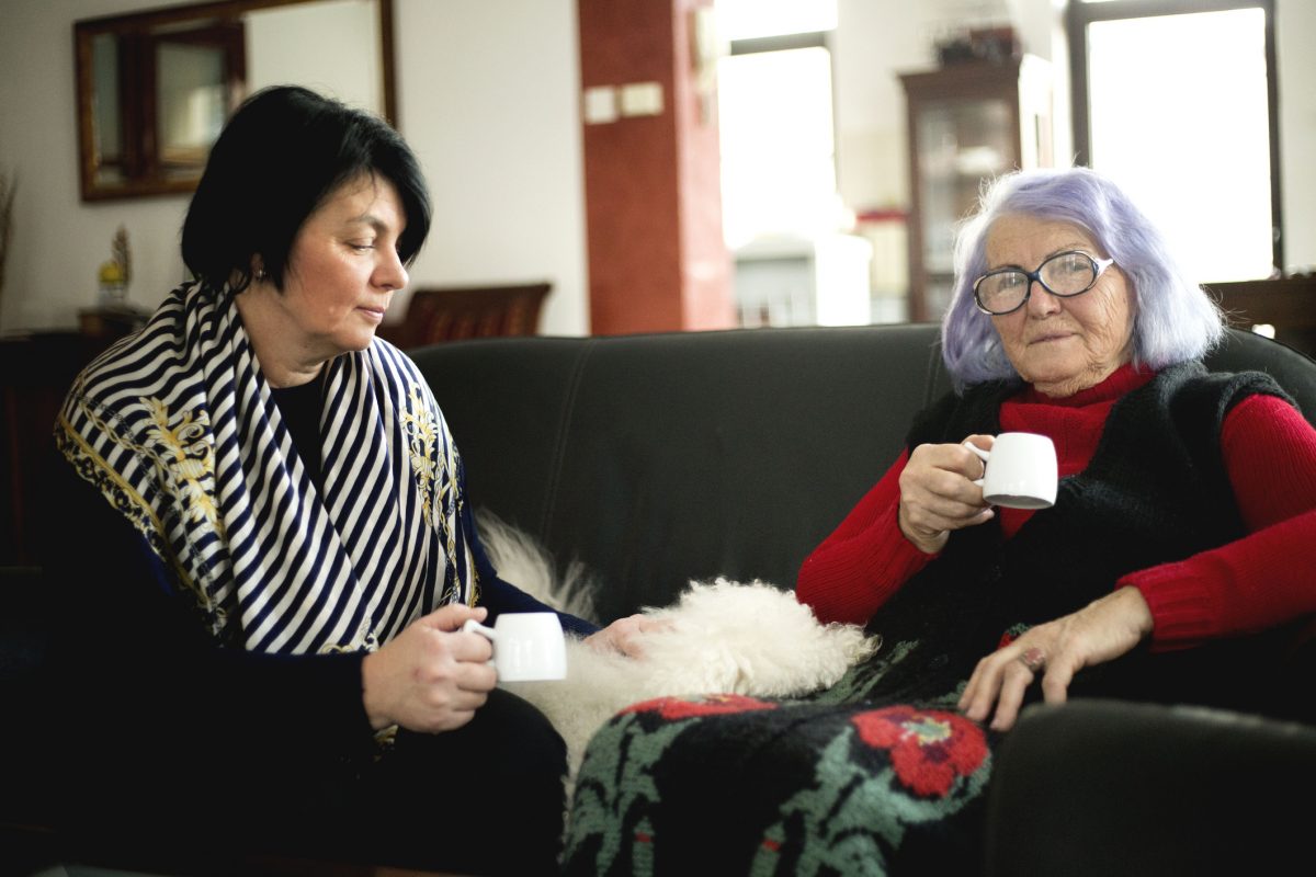 two women sitting on sofa