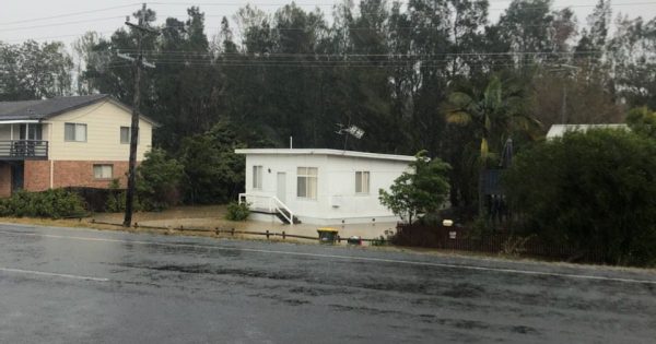 Fears for bushfire victims as torrential rain lashes coast