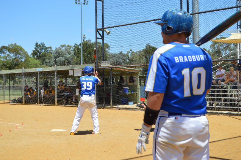 Jarrod Bradbury watching his brother, Jeremy, batting in game of softball.