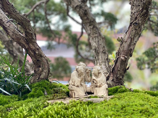 Three characters in penjing display.