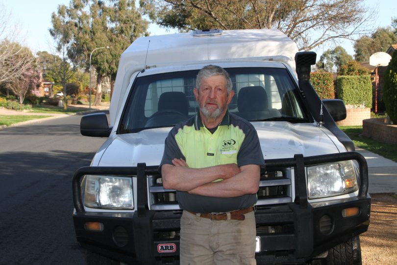 Jim Holmes leaning on work vehicle.