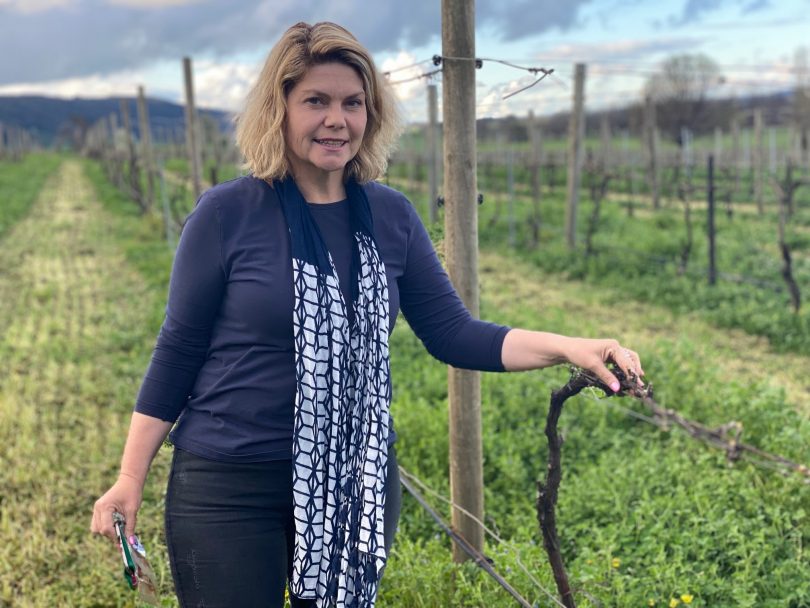 Lake George Winery owner Sarah McDougall standing in vineyard.