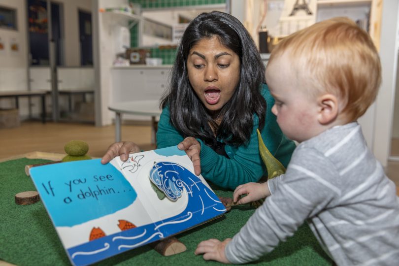 Kavita Ogale reading book to child.