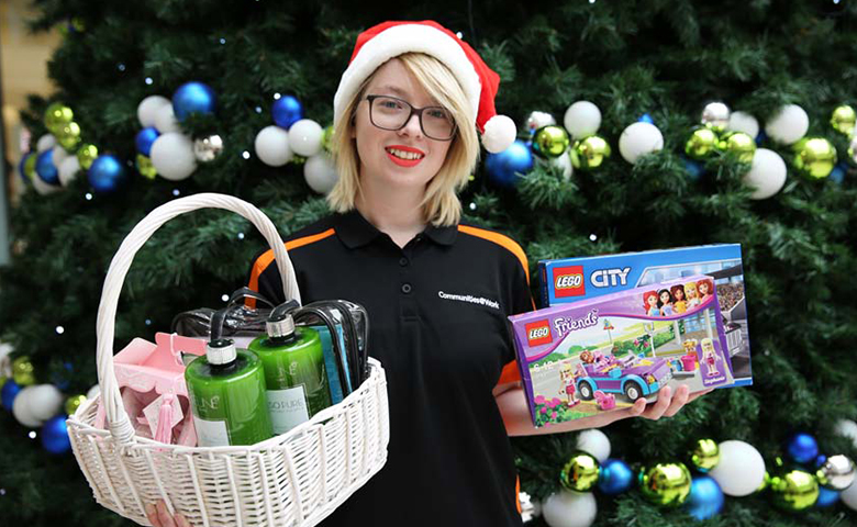 Communites@Work staff member holding hamper and toys.