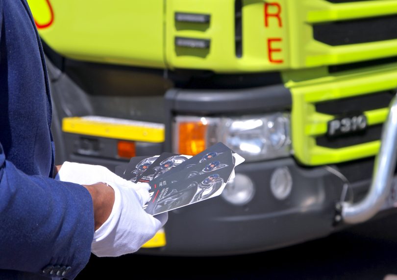 Man holding new $2 coins honouring firefighters.