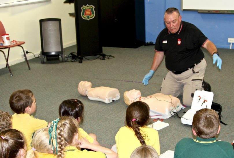St John Ambulance paramedic Darryl Rice show students at Captains Flat Primary School how to use an AED.
