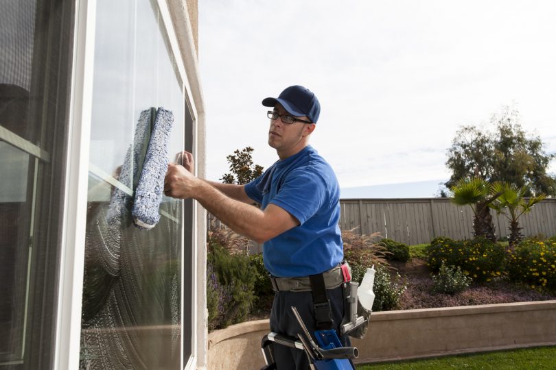 Man cleaning window of a home