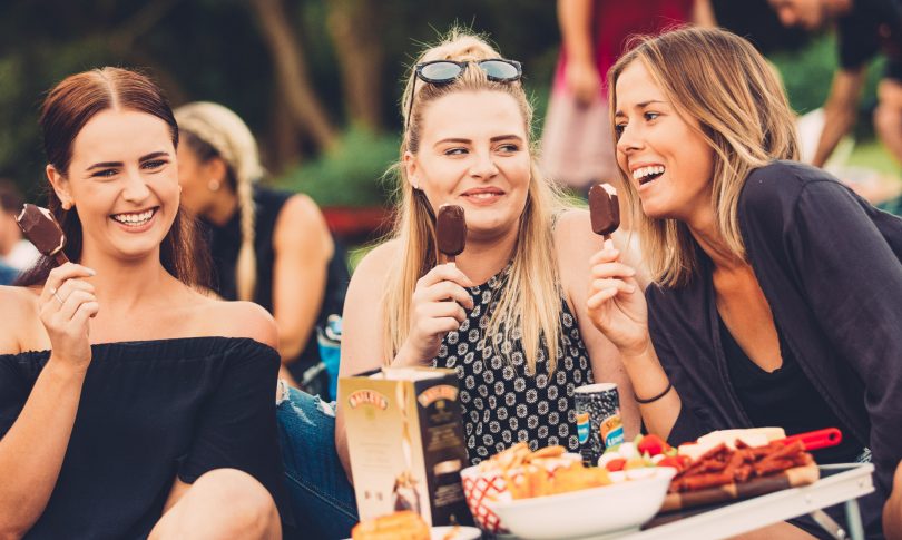 Women at Sunset Cinema eating ice-cream and laughing.