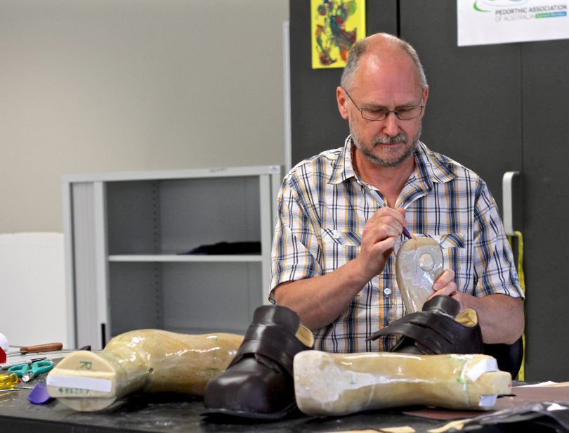 Pedorthist Stuart Gamgee works on new orthotic shoes for patients in his workshop.