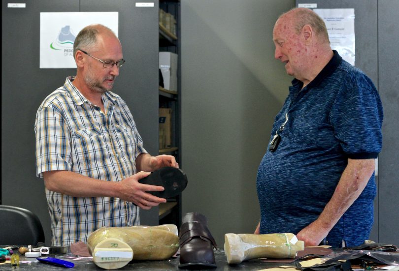 Stuart Gamgee and Tony Bailey discuss orthotic shoes in the workshop.