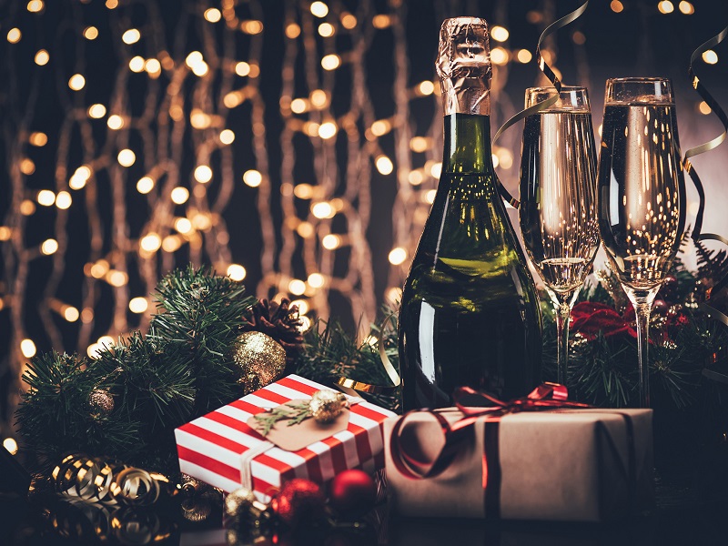 Festive decorations, presents and sparkling wine bottle and glasses.