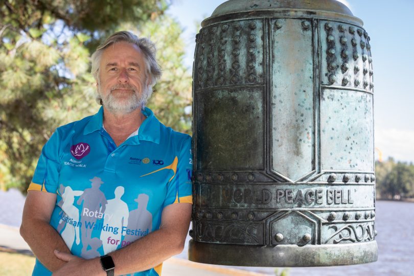 Man leaning against a large bell