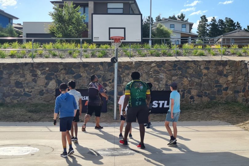 Youths playing basketball in the Molonglo Valley.