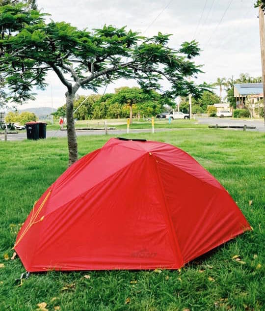 Red tent pitched on grass