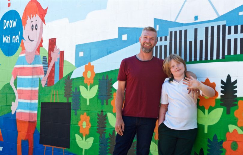 Artist Geoff Filmer and his son Gus in front of the mural painted by Geoff
