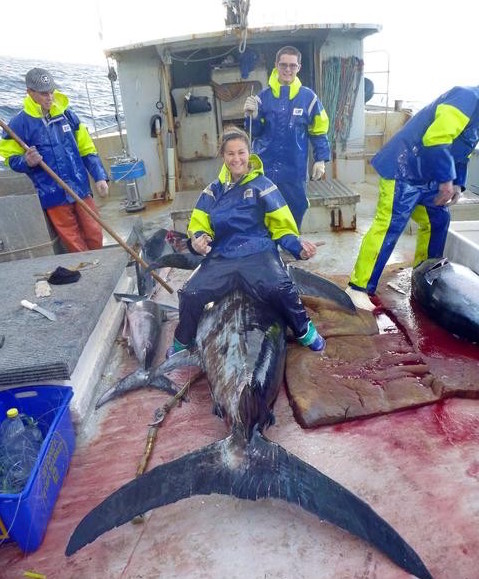 The team from Narooma Seafood Direct on a boat with fish caught in open water.