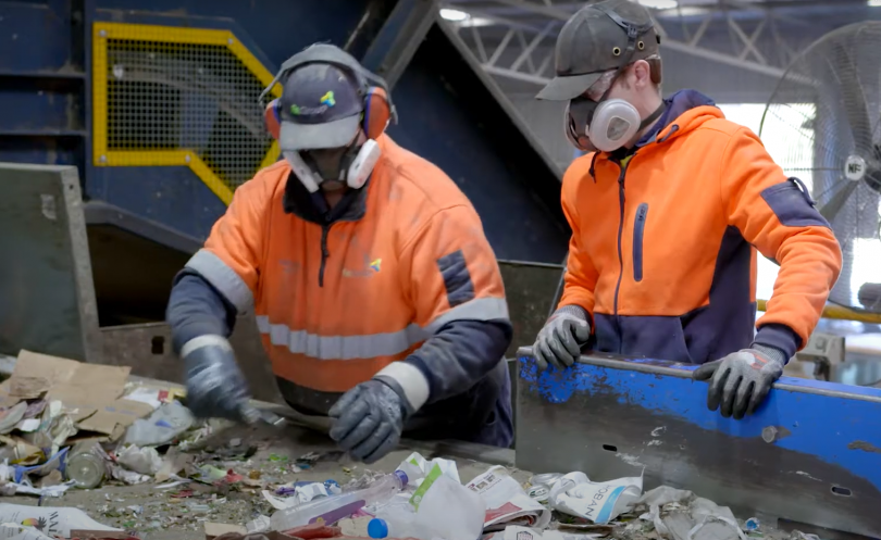 Two workers sifting through recycling at Materials Recovery Facility in Hume.