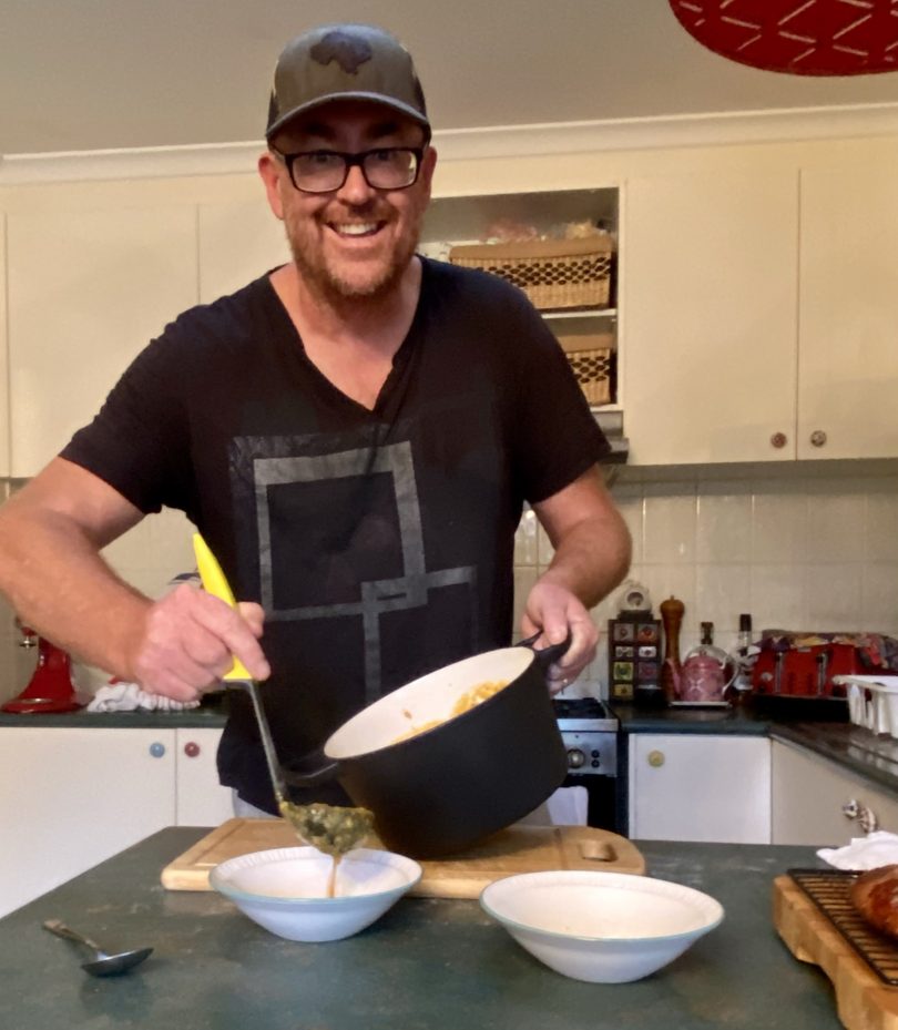 Joshua Brandt Rosner serving meal in kitchen at home.