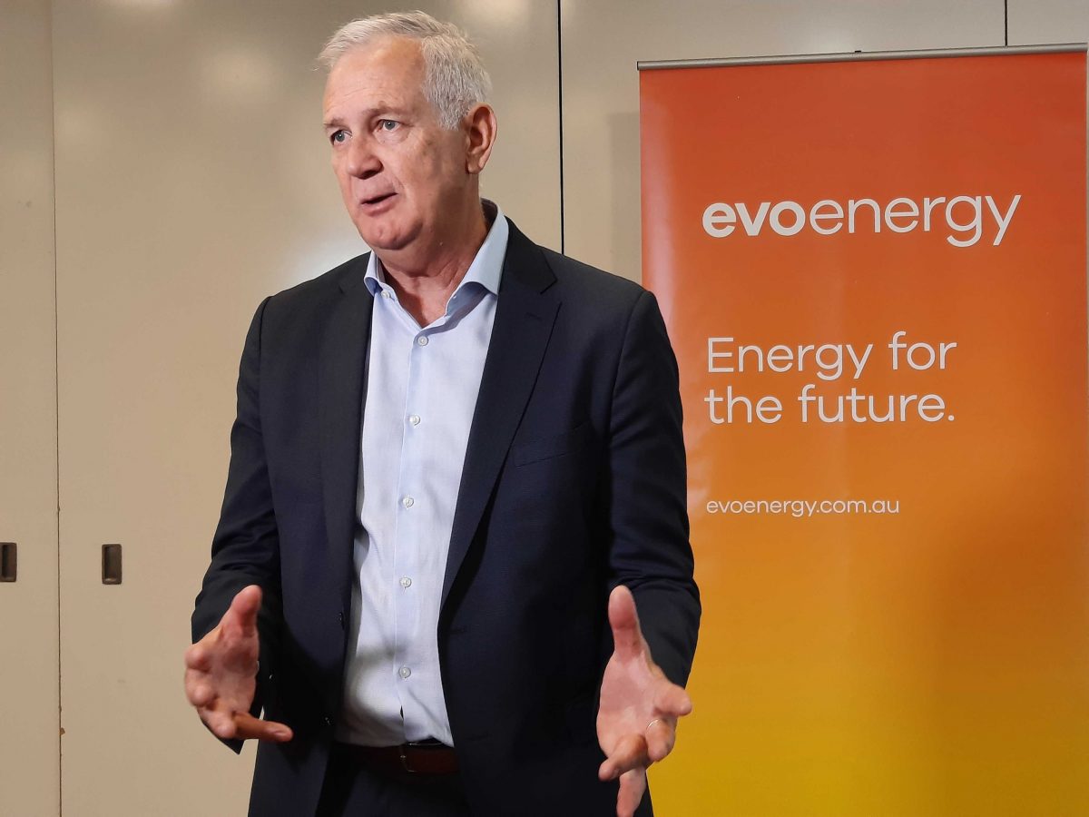 Man in suite in front of an evoenergy banenr