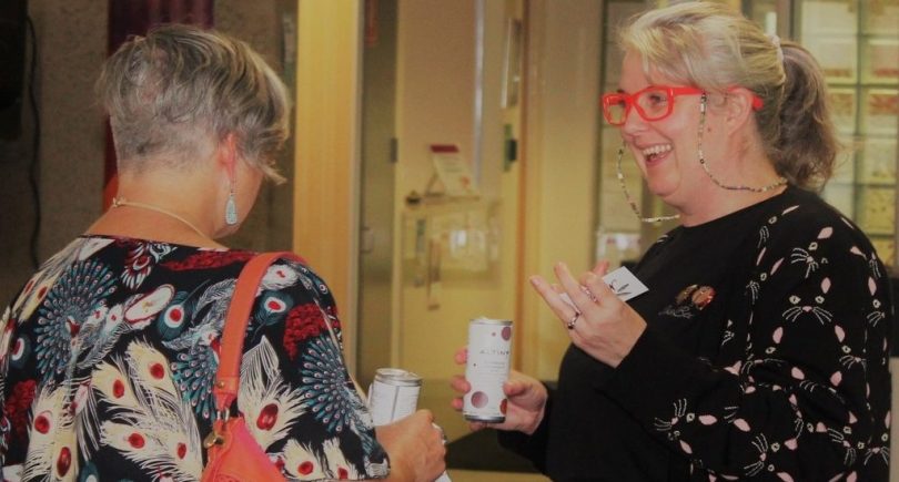 Two women chatting and having a drink at corporate event