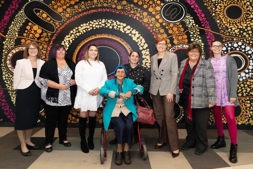 Group of women in front of artwork at ACT Health office